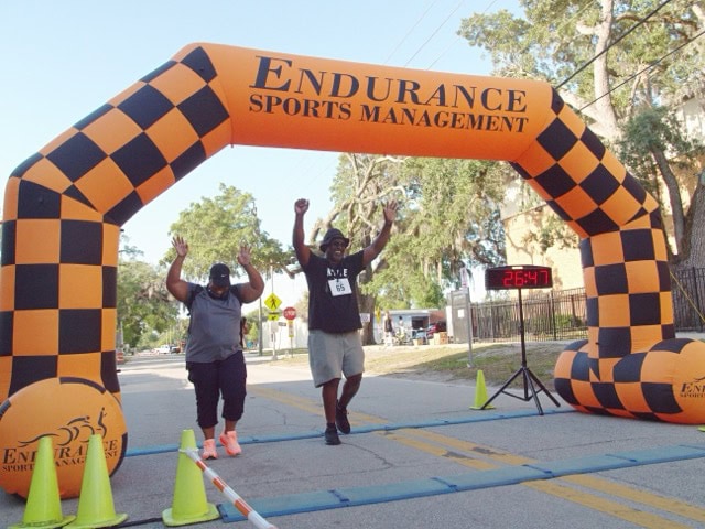 Two participants celebrating as they cross the Hearts Against Hunger 5K finish line